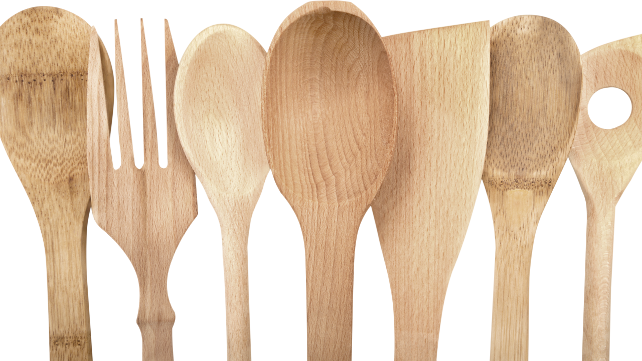Various clean and smooth wooden cooking utensils lined up vertically on white background.