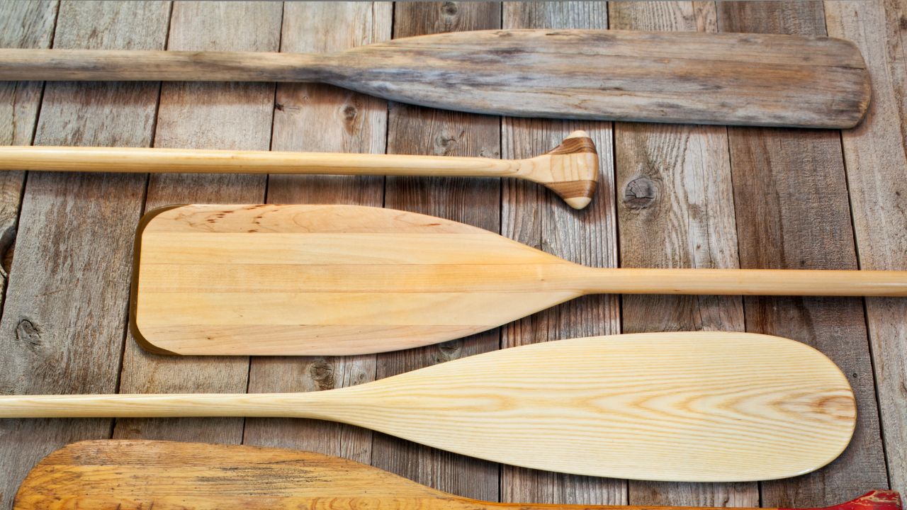 Old and discolored wooden utensils laid on rustic wooden surface, showing signs of wear and damage.