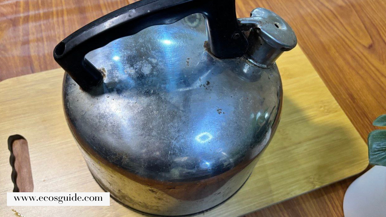 Dirty kettle before cleaning Old stainless steel kettle with visible grime and dull surface.