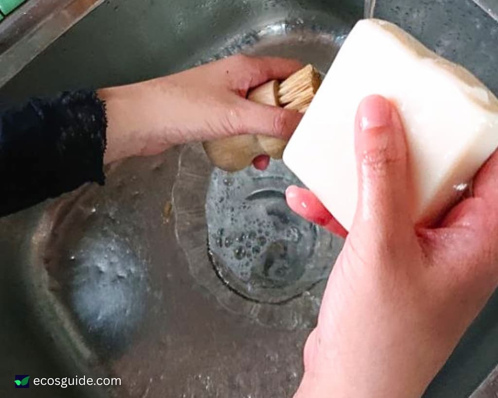 Washing a dish soap bar under the kitchen tap