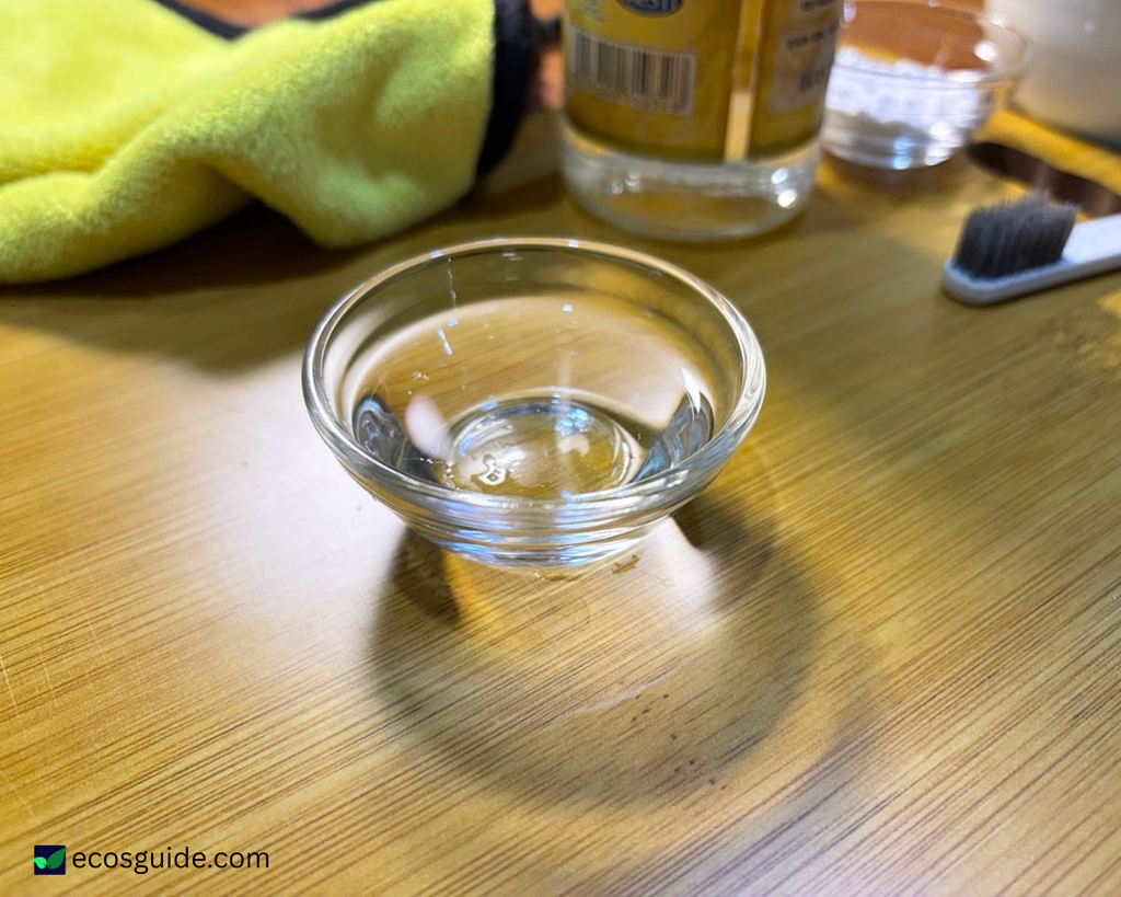 Distilled white vinegar measured into a small glass bowl for the dishwasher cleaning cycle