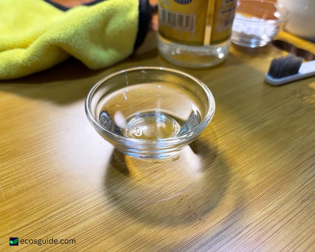 Distilled white vinegar measured into a small glass bowl for the dishwasher cleaning cycle
