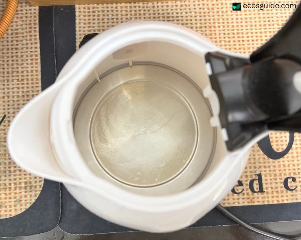 Looking down into an open plastic electric kettle showing the polypropylene interior and metal heating plate